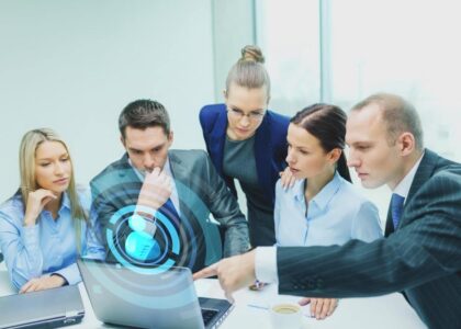 grupa zaposlenih ispred laptopa zajednicki se edukuju